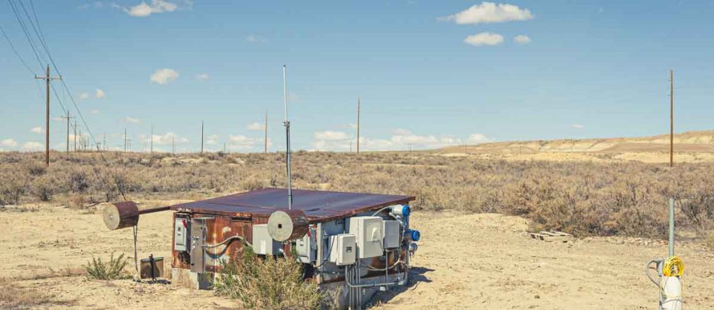 weathered building with attached equipment in the desert