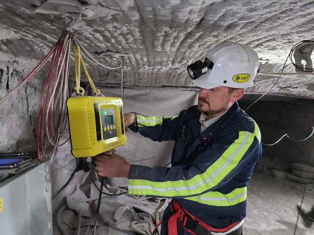 man in reflective gear adjusting equipment underground