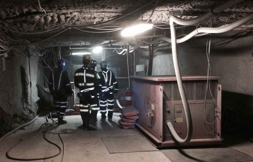 Miners in reflective gear at charging station