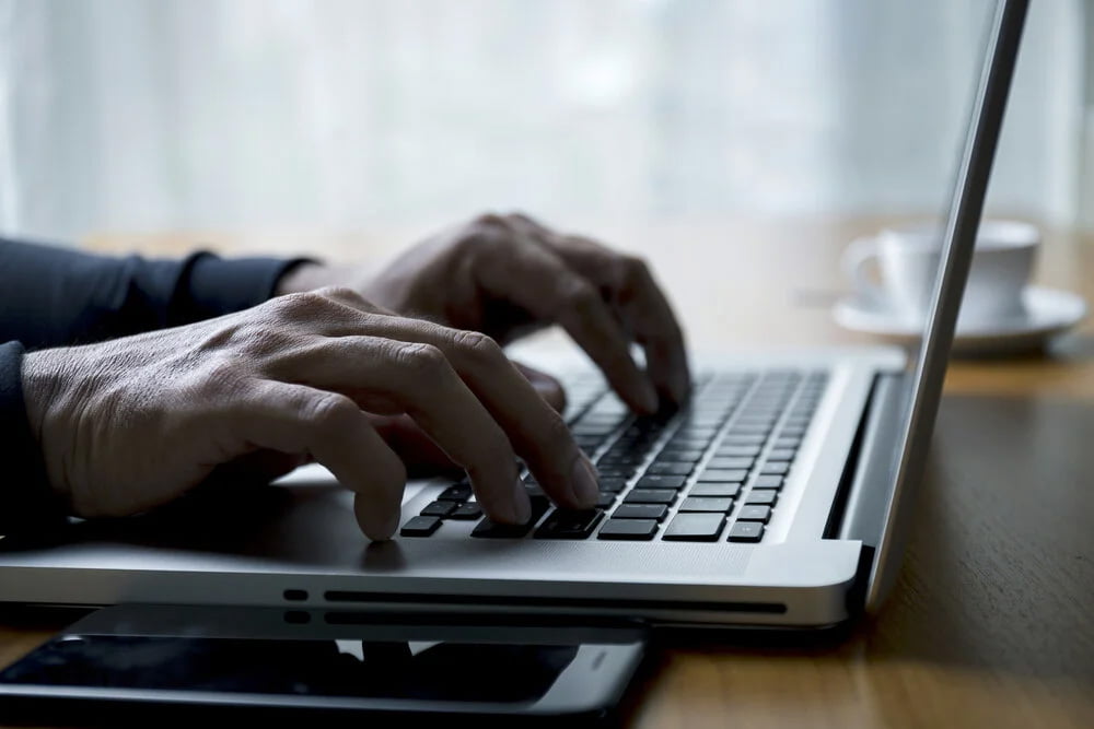 hands typing on laptop